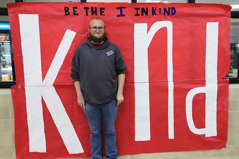 man making the I in Kind on poster